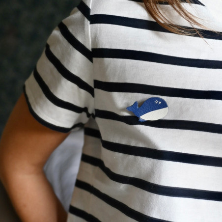 broche en cuir en forme de baleine portée sur un teeshirt marinière