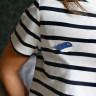 broche en cuir en forme de baleine portée sur un teeshirt marinière